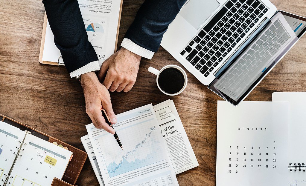 Desk with business charts, laptop and documents under review